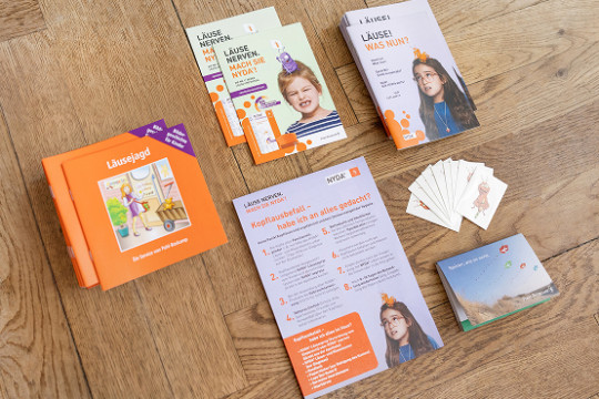 NYDA-Servicepaket mit Broschüren, Karten, Faltblättern und Informationsmaterial auf einem Holzboden.