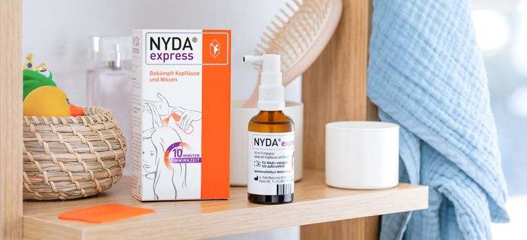 Eine Packung NYDA® express, das Silikonöl enthält, steht auf einem Regal im Badezimmer